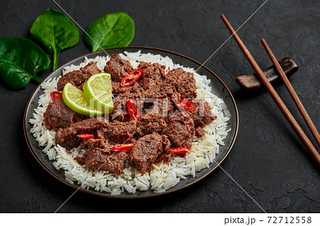 Beef Rendang on black plate at black slate table top. Indonesian padang cuisine meat dish Beef Rendang on black plate at black slate table top. Indonesian padang cuisine meat dish 72712558
