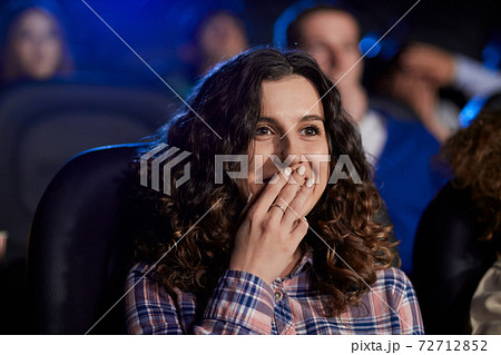 Young laughing girl watching comedy in movie theater. Young laughing girl watching comedy in movie theater. 72712852
