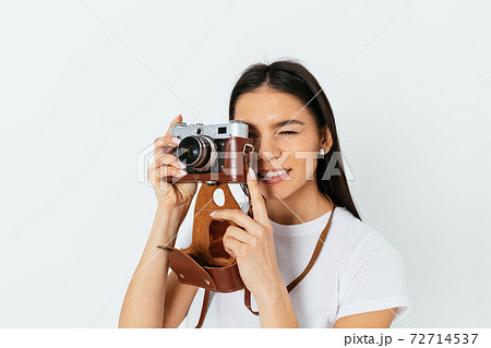 Young woman takes pictures on a retro camera 72714537