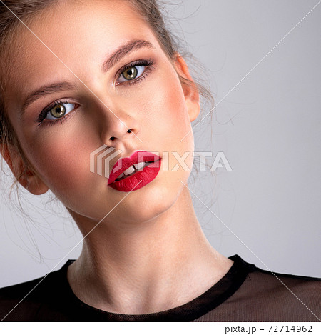 Beautiful photoshopped brown-hair girl. Pretty caucasian girl with a tilted head and red lipstick. Beautiful photoshopped brown-hair girl. Pretty caucasian girl with a tilted head and red lipstick. 72714962