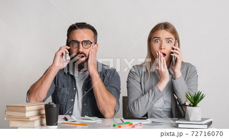 Frightened and shocked man with beard and glasses and with open mouths in workplace 72716070