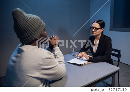 A pretty lawyer girl is having a conversation with a drug dealer client at the police station A pretty lawyer girl is having a conversation with a drug dealer client at the police station 72717159