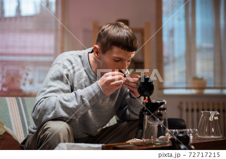 The process of tea ceremony at home. The tea master puts pieces of raw aged black tea in a teapot on a bamboo tray. 72717215