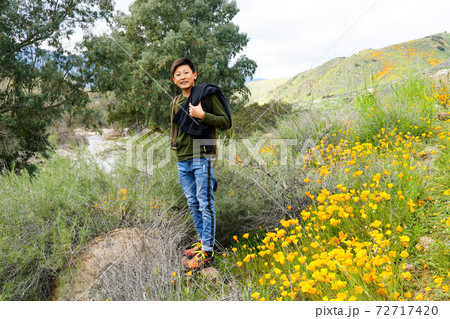 Young sporty Asian boy enjoying and hiking the mountain during the California Golden Poppy  72717420
