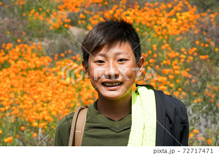 Young sporty Asian boy enjoying and hiking the mountain during the California Golden Poppy  72717471