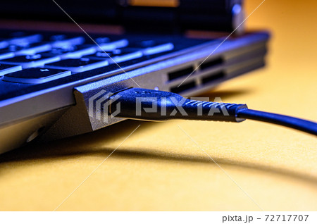 Close-up connected the smartphone to the USB connector to the laptop for charging. 72717707