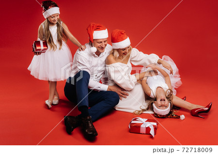 Portrait of a happy family in a Christmas hat on a red background 72718009