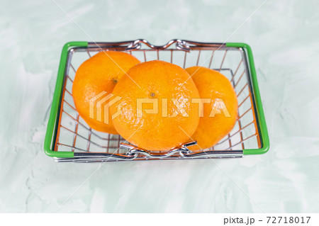 Fresh mandarins in a small shopping busket 72718017
