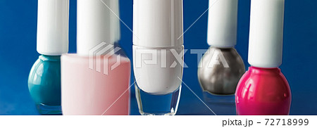 Nail polish bottles on dark blue background, beauty brand 72718999