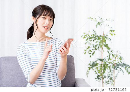 A woman who operates a smartphone while - Stock Photo [72721165] - PIXTA