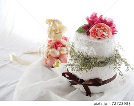 白い布に乗せられた手作りのクレイケーキとマカロンタワーの写真素材