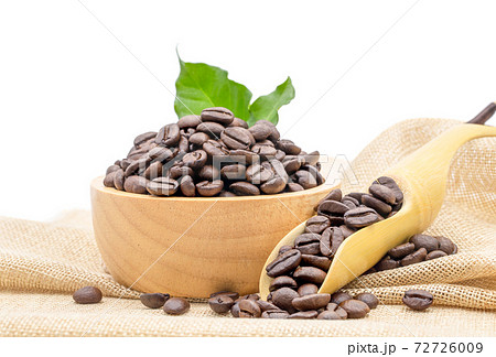 Coffee beans roasted in a wooden bowl and beans scoop on sackcloth isolated over white background. 72726009