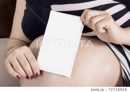 Woman holding unborn baby ultrasound X-Ray image in hands in front of belly mock-up series Woman holding unborn baby ultrasound X-Ray image in hands in front of belly mock-up series 72728958