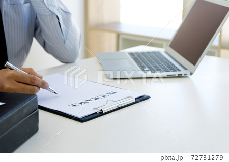 businessman sit and sign the insurance document paper on the table 72731279