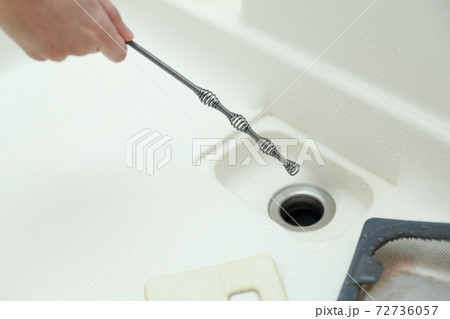 排水溝の詰まりを掃除する主婦 72736057
