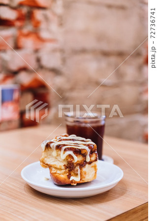 A plate of mini cinnamon rolls and a cup of black coffee 72736741