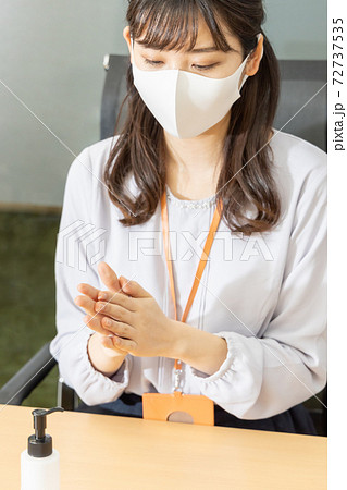 アルコールで手を消毒するマスクをした女性 72737535