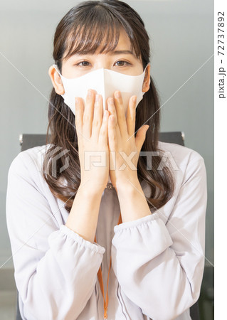 口元のマスクを両手で押さえる女性 口元のマスクを両手で押さえる女性 72737892