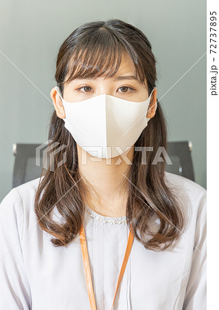 正面を見つめるマスクをした女性 72737895
