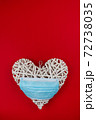 White heart with a blue face mask on a red background. Concept of a Valentines day during Coronavirus or Covid pandemic. 72738035