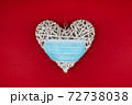 White heart with a blue face mask on a red background. Concept of a Valentines day during Coronavirus or Covid pandemic. 72738038