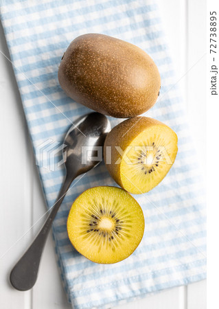 Halved ripe yellow kiwi fruit. 72738895