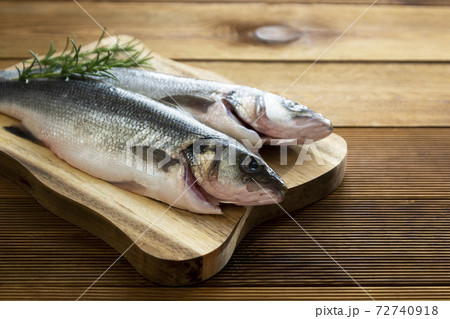 Seabass fish isolated on wooden background, top view. 72740918