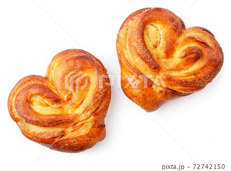 Yeast dough buns in the form of a heart on a white background, isolated. The view from top 72742150