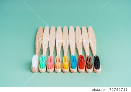 A set of Eco-friendly antibacterial toothbrushes made of bamboo wood on a light green background. Environmental care trends A set of Eco-friendly antibacterial toothbrushes made of bamboo wood on a light green background. Environmental care trends 72742711