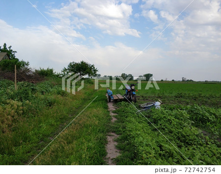Old motorcycle with a sidecar on a deserted village road in the field. Rural transport Old motorcycle with a sidecar on a deserted village road in the field. Rural transport 72742754