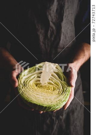 Man is Holding Halved White Cabbage Man is Holding Halved White Cabbage 72743713