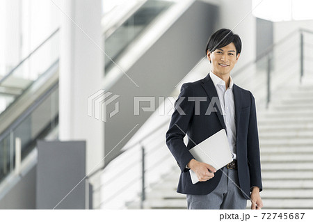 ノートパソコンを持った若いビジネスマン ノートパソコンを持った若いビジネスマン 72745687