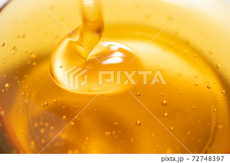 ガラスボールに注がれるハチミツシロップ 写真素材 ガラスボールに注がれるハチミツシロップ 写真素材 72748397