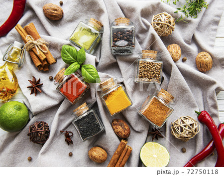Jars with dried herbs, spices on the table Jars with dried herbs, spices on the table 72750118