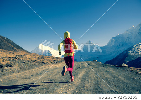 Woman trail runner cross country running in winter mountains Woman trail runner cross country running in winter mountains 72750205