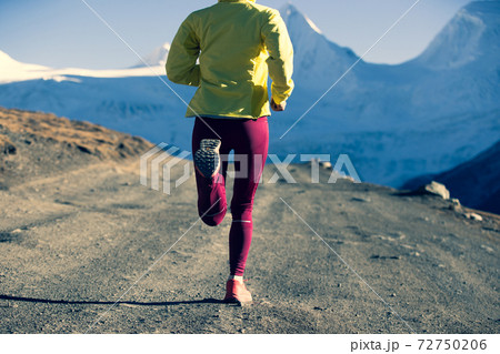 Woman trail runner cross country running in winter mountains Woman trail runner cross country running in winter mountains 72750206
