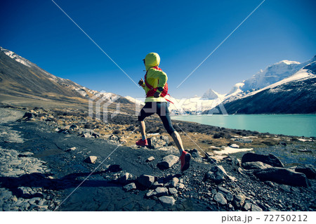 Woman trail runner cross country running in winter mountains Woman trail runner cross country running in winter mountains 72750212