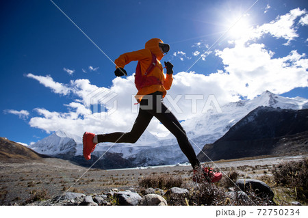 Woman trail runner cross country running in high altitude winter nature Woman trail runner cross country running in high altitude winter nature 72750234