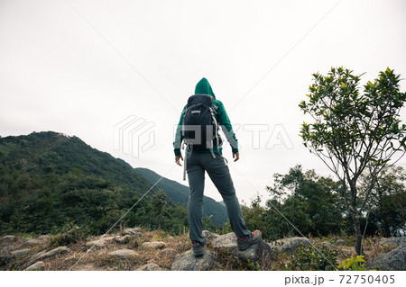 Woman hiker hiking in winter tropical mountains 72750405