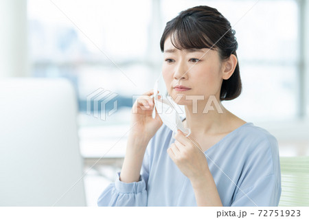 オフィスでマスクのため肌荒れを気にする女性 72751923