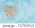 White heart on a background of a blue faces masks. Concept of a Valentines day during Coronavirus or Covid pandemic. 72753513