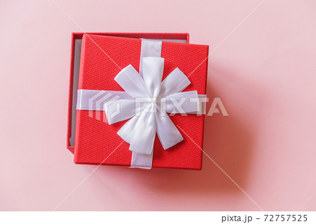 Christmas New Year birthday valentine celebration present romantic concept. Simply minimal design red gift box isolated on pastel pink colorful background. Flat lay top view, copy space 72757525