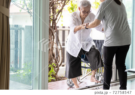 Asian caregiver help care to senior grandmother walk,woman holding hands of the old elderly for support,walking up from a different level floor,safety,prevent accident at nursing home,service concept 72758547