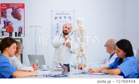Medical doctor man pointing on cervical spine of human skeleton 72760458