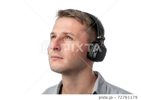 Young guy DJ, European, on a white background in headphones, listens to music, having fun. Young guy DJ, European, on a white background in headphones, listens to music, having fun. 72761179