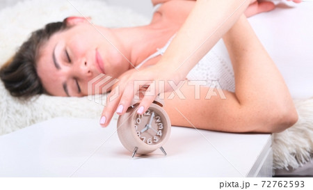 Woman sleep on the bed turns off the alarm clock wake up at the morning, Selective focus. 72762593