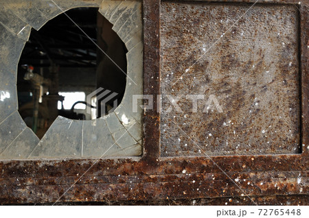 rusty factory door and smashed glass 72765448