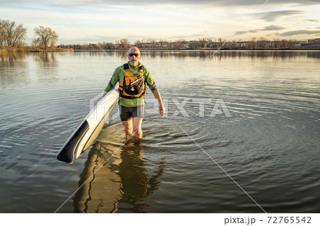 senior man with stand up paddleboard 72765542