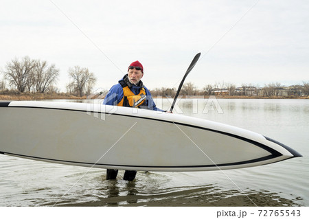 senior man with stand up paddleboard 72765543