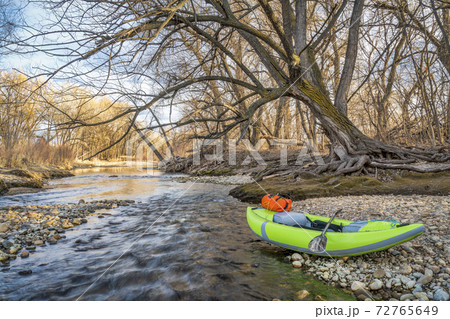 whitewater inflatable kayak on a river shore whitewater inflatable kayak on a river shore 72765649
